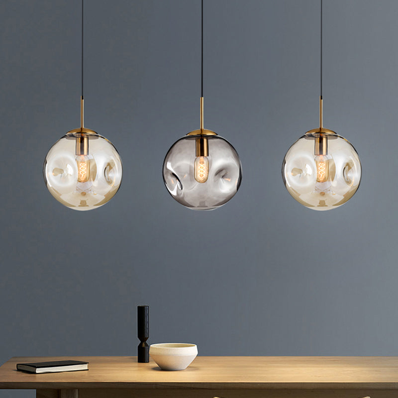 Dimpled Sphere Ceiling Pendant Modern Cognac/Smoke Grey Glass 1 Head Brass Hanging Light Fixture for Living Room Clearhalo 'Ceiling Lights' 'Glass shade' 'Glass' 'Modern Pendants' 'Modern' 'Pendant Lights' 'Pendants' Lighting' 1937208