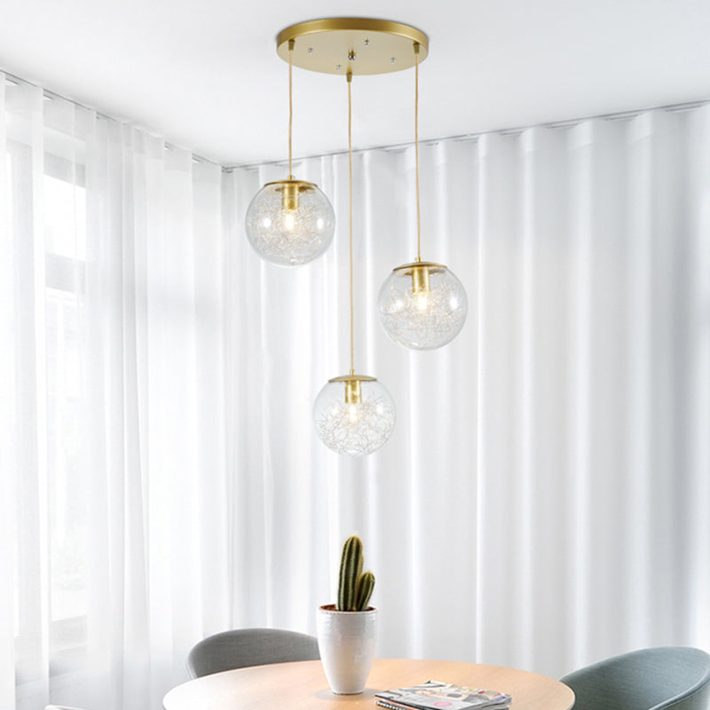 Minimalist Pumpkin Ball Multi Light Pendant Clear Glass 3 Lights Coffee House Hanging Lamp in Gold with Metal Line Deco Inside Clearhalo 'Ceiling Lights' 'Glass shade' 'Glass' 'Modern Pendants' 'Modern' 'Pendant Lights' 'Pendants' Lighting' 731482