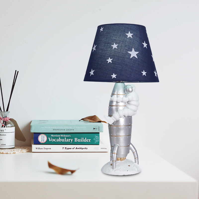 Silver Rocket and Astronaut Table Light Kids 1 Bulb Resin Night Lamp with Barrel Fabric Shade Silver Clearhalo 'Lamps' 'Table Lamps' Lighting' 882745